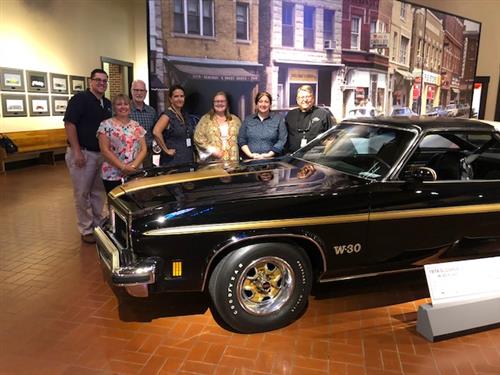 Students, Staff, and Designers around car at Gilmore Car Museum 